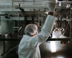 Employee operates sachet packaging machine.